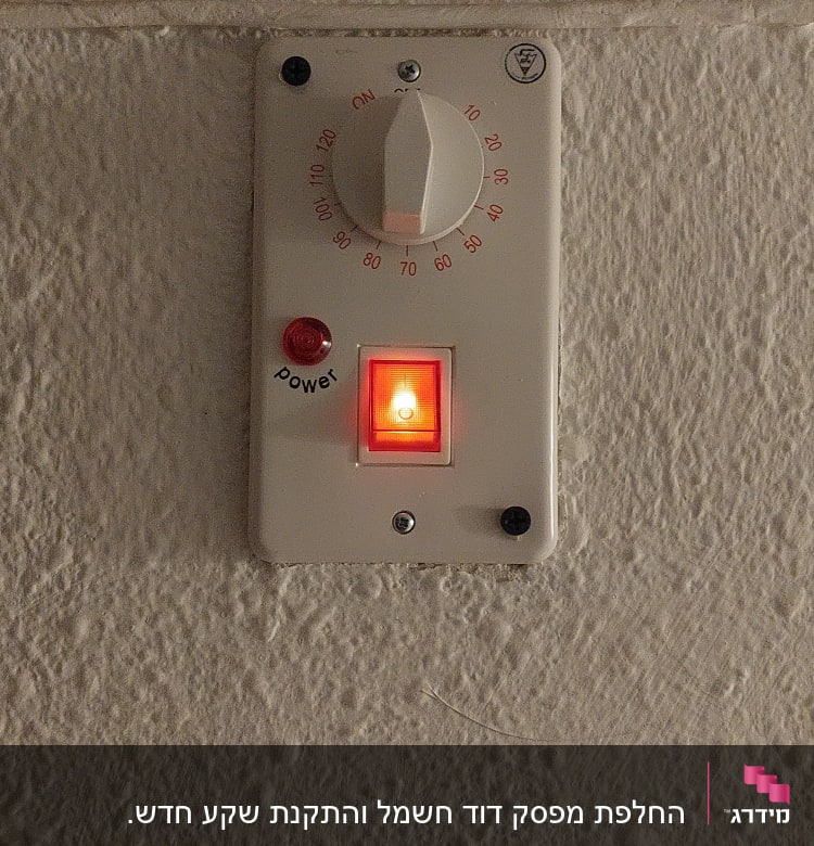 תרמוסטט עם כפתור אדום מואר על קיר